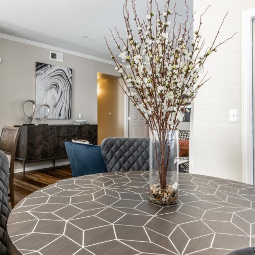 Beautiful living spaces with natural lighting a dining room with a vase of flowers on a table with chairs